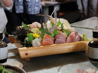 A very well decorated plate of sashimi: thin slices of raw fish, they are delicious with soy sauce.
