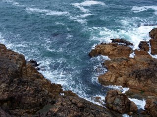 Look down at the swirling ocean around the rocks