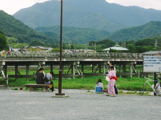 By the Katsura River, the local tourists are relaxing and enjoying the afternoon in Summer. Togetsukyo&nbsp;in the background is one of famous bridges in Arashiyama