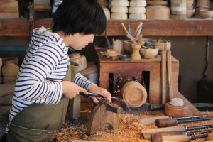 Creating her own wooden pot