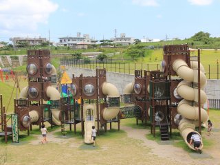 The playground equipment for 6 to 12 year old children features connected multi-level structures with external zip lines, monkey bars and rope obstacles