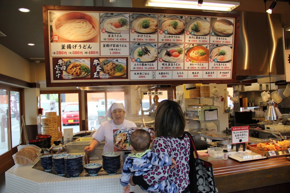 The menu board and display placards are strictly in Japanese, but there is a laminated flyer available that shows all offerings with descriptions in English and Korean