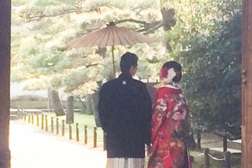 <p>A couple standing at a gate inside Rinshunkaku</p>