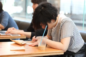 <p>One of the patrons busy sketching her designs</p>