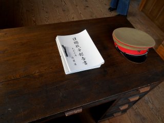 机の上に置かれた所長帽と、陸軍省の日独戦争報告書