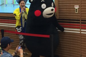 Kumamon makes his way to the stage with his mate. Because he can&#39;t speak, his mate interprets in Kumamoto dialect.