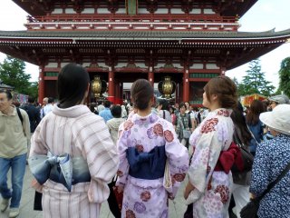 Ba người phụ nữ xúm xính trong trang phục Kimono truyền thống lướt qua dòng người đông như kiến