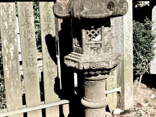 An old lantern statue against an old wooden fence