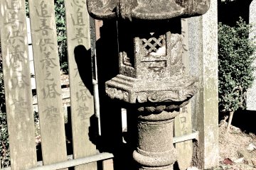 <p>An old lantern statue against an old wooden fence</p>