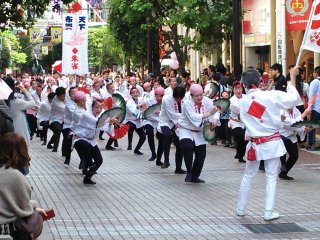 Suzume Odori groups dance down the covered arcades to bright, cheerful music.