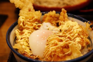 <p>ไข่ ค่อยๆไหลลงไปตามช่องว่าง ใช้ตะเกียบเจาะให้ไข่แดงกระจายไหลเยิ้มซึมและเคลือบเม็ดข้าวเห็นเป็นสีส้มสดใส พร้อมแล้วที่จะกิน</p>