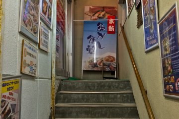 <p>The stairwell leading to&nbsp;Hamakura&nbsp;offers pictures of sashimi sets and the art of tuna direct&nbsp;from the market.</p>