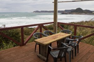 Outdoor seating looks onto the incoming waves