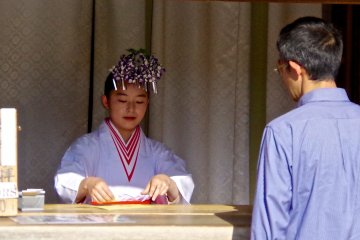 <p>Shinto maidens wear wisteria decorations in May</p>