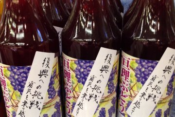 <p>Bottles of grape juice from Yamamoto Town with &quot;Challenge to the recovery&quot; labels</p>