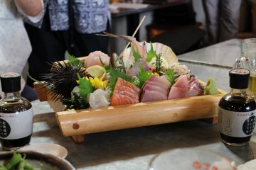 <p>A very well decorated plate of sashimi: thin slices of raw fish, they are delicious with soy sauce.</p>
