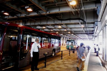 <p>The hotel shuttle buses of the Imperial Hotel Osaka (red) and the Rihga Royal Hotel (green) are waiting at the Sakurabashi Gate Bus Stop at JR Osaka station. The bus stop is just in front of the pub</p>