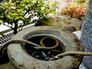 A coil of rope in a stone water basin