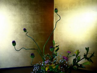 Ikebana arrangement in the entrance, backed by a beautiful gold screen