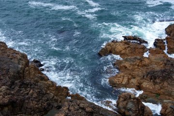 <p>Look down at the swirling ocean around the rocks</p>