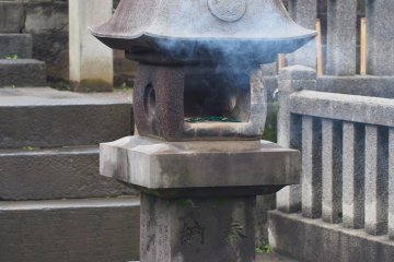 <p>Люди отдают дань уважения к Акороши, сжигая ароматические палочки на кладбище</p>