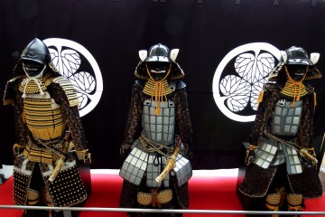<p>Three armor-clad dolls of samurai are displayed in the museum lobby</p>