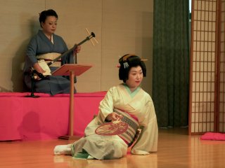 Người vũ công, cô Shiori, đang nằm trên sân khấu với tư thế gợi cảm