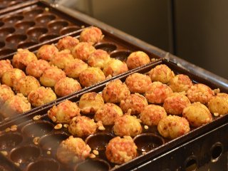 Takoyaki cooking in their special pans