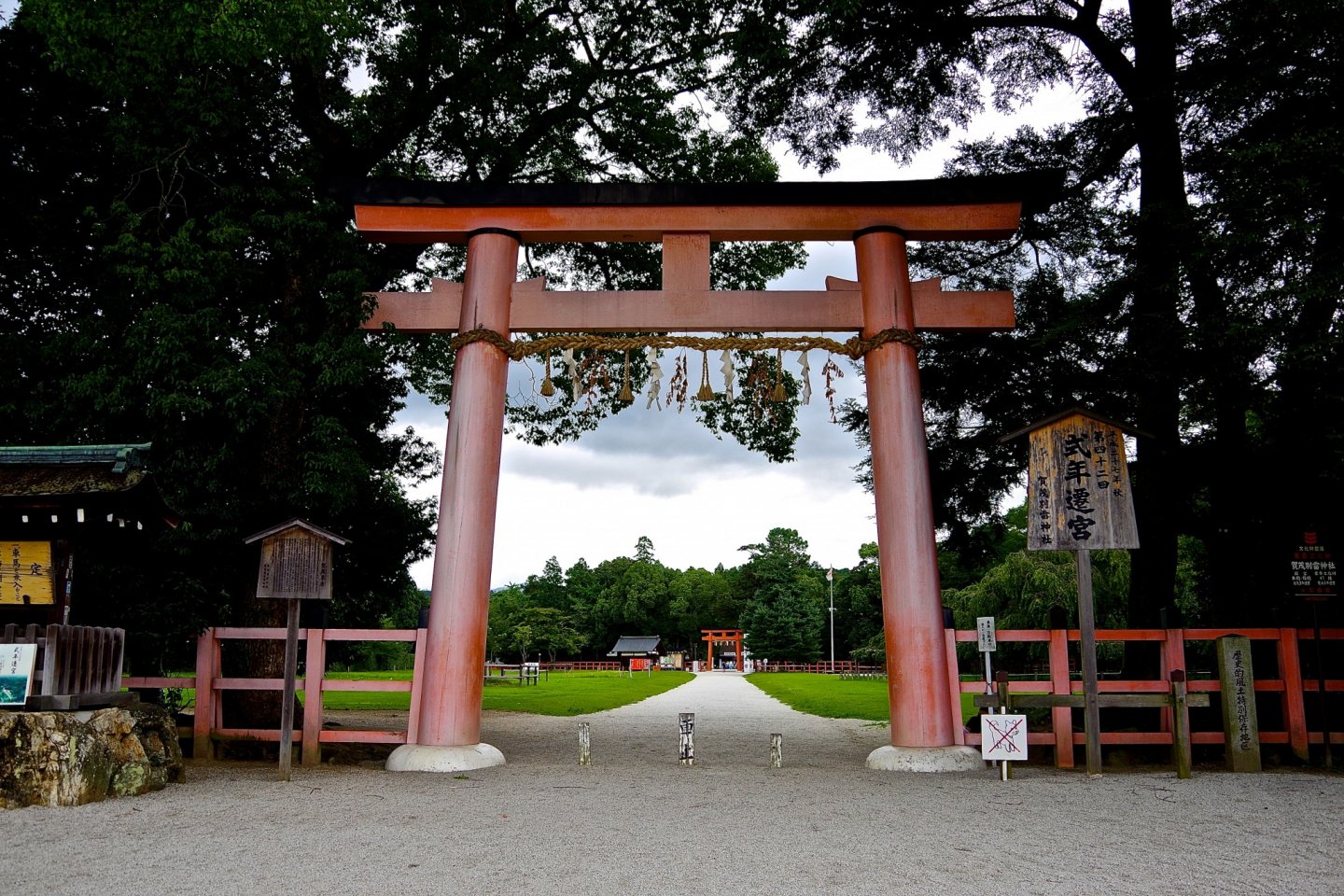 A long approach cuts through a wide open field between these two torii gates