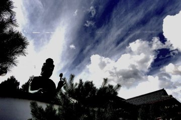 푸른 하늘 아래에서 흰 구름 줄무늬가 있는 태양을 등에 업은 후쿠이 대불