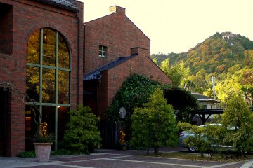 <p>The shop and cafe are housed in a graceful red brick building. You can see Omihachiman&#39;s cable car in the background.</p>