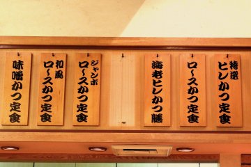 <p>Menu written on pieces of wooden board on the wall</p>