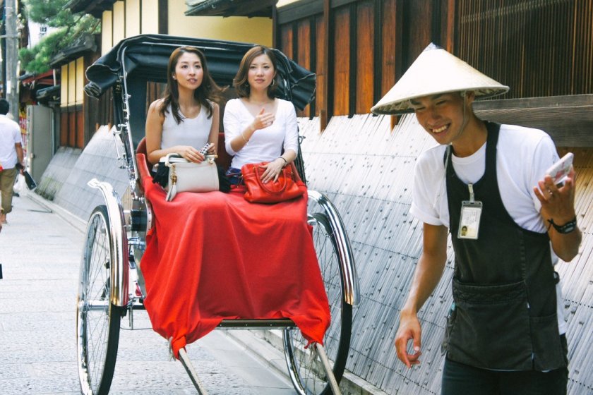 Dua orang turis lokal yang akan menikmati Kyoto dengan 'becak' khas Jepang