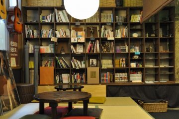 Ugaya Guesthouse's common area is stocked with books, souvenirs, and maps.