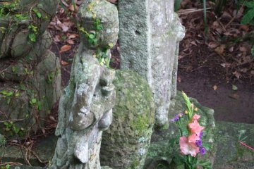 An ancient, lone statue that is well cared for.
