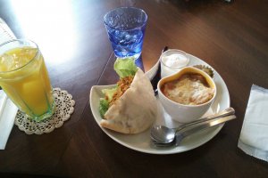 The delicious &quot;Palette&quot; lunch set - a pita bread filled with dry curry and lettuce, onion soup gratin, blancmange and a drink