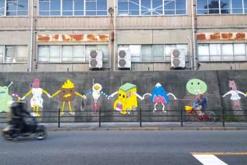 <p>อีกหนึ่งผลงานศิลปะอันโดดเด่นประจำท่าเรือ NAMURA DOCK ซึ่งเป็นการวาดรูปบนกำแพงอย่างมีสีสันในธีม b.friends on the wall ของกลุ่มศิลปิน b.friends</p>