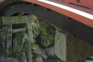 The red color of the bridge makes a beautiful contrast with the surrounding green leaves 