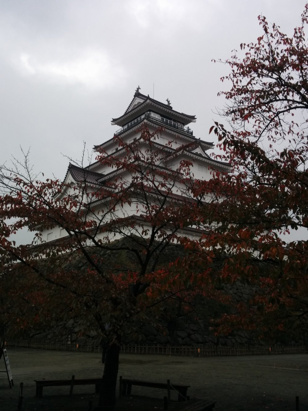 The castle on a rainy day, obscured by red leaves