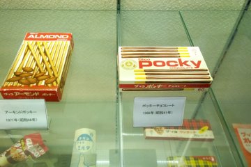 <p>ในปี ค.ศ.1966 ได้มีการสร้างสรรค์ผลิตภัณฑ์ขึ้นใหม่โดยการนำขนมปังแท่งกรอบไปเคลือบช็อกโกแลต ผลิตภัณฑ์ใหม่นี้ถูกตั้งชื่อว่า Pocky (ภาพขวา) หลังจากวางขายแล้วมันได้รับความนิยมอย่างสูงซึ่งป๊อกกี้รสช็อกโกแลตนั้นถือเป็นรสแรกของขนมยอดนิยมระดับโลกนี้ ก่อนที่จะตามมาด้วยป็อกกี้รสช็อกโกแลตผสมแอลม่อนในปี ค.ศ.1971 แล้วก็ตามด้วยป็อกกี้รสยอดนิยมอย่างสตรอเบอร์รี่ที่วางขายครั้งแรกในปี ค.ศ.1976 ซึ่งรสนี้กลายเป็นที่นิยมอย่างแพร่หลายรวดเร็ว และถือเป็นหนึ่งในสองรสชาติเอกลักษณ์ของป็อกกี้ตลอดกาล</p>