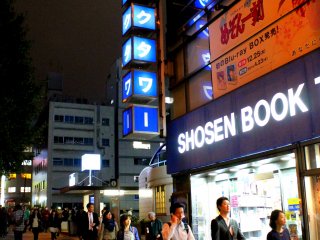 Several Akiba locals and expatriates walk past the bookstore&#39;s main entrance