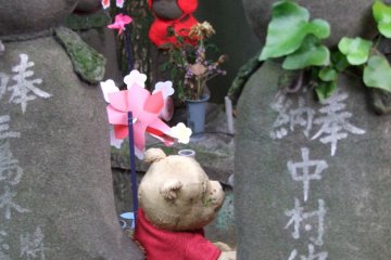 Pequeños juguetes y animales de peluche (como este oso Pooh) a menudo se dejan en la base de la estatua