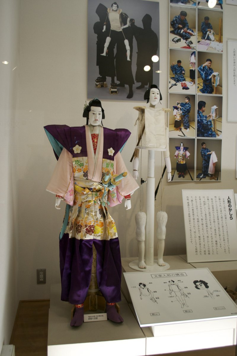 <p>A Bunraku puppet fully dressed, and behind it the puppet&#39;s &quot;skeleton&quot;&nbsp;</p>