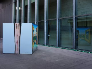 A promotional box displaying the current exhibition