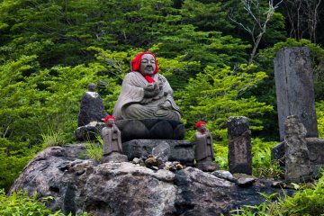 <p>The statues wear bibs or children&#39;s clothing, they are put on the statues by grieving parents wishing protection for their lost child.</p>