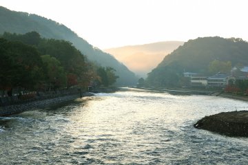 The morning sun filtering through the mist over Uji River as it flows from the mountains