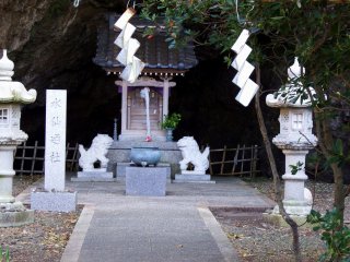 Stone lantern, stone marker and two guardian dogs in front of the main altar of Daffodil Shrine