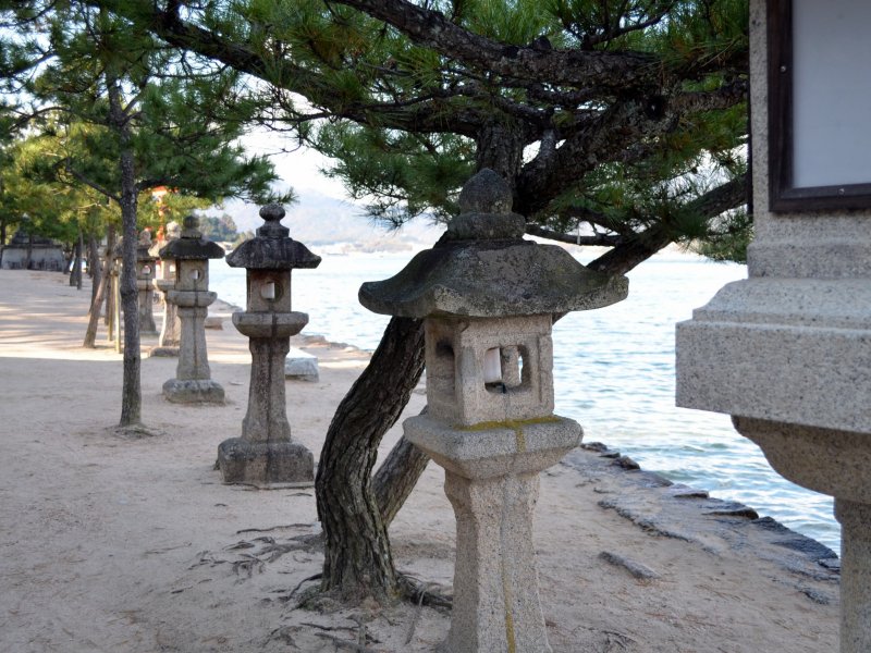 <p>Stone lanterns and tress on the beach</p>