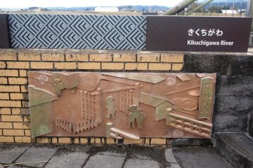 <p>A relief showing rice merchants at the riverbank entrance to the Buzen Way</p>