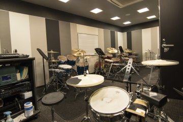 <p>Classroom for drums lessons. The set before me is for the teacher, with his drum set facing the rest and the PA handy to his left.</p>